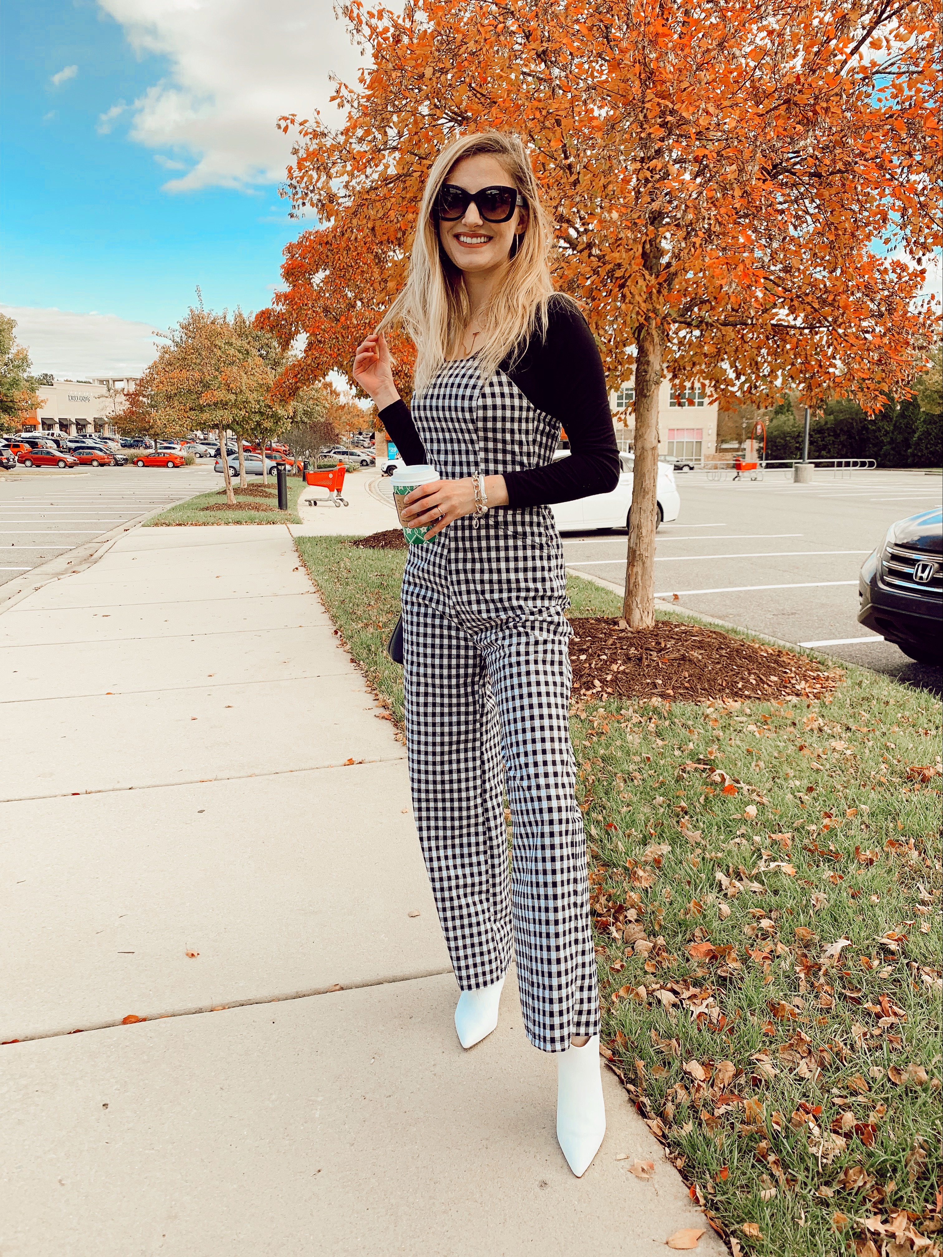 Fashion Inspiration by North Carolina fashion and lifestyle blogger Jessica Linn. Wearing a black and white checkered jumpsuit and white pointed toe boots.
