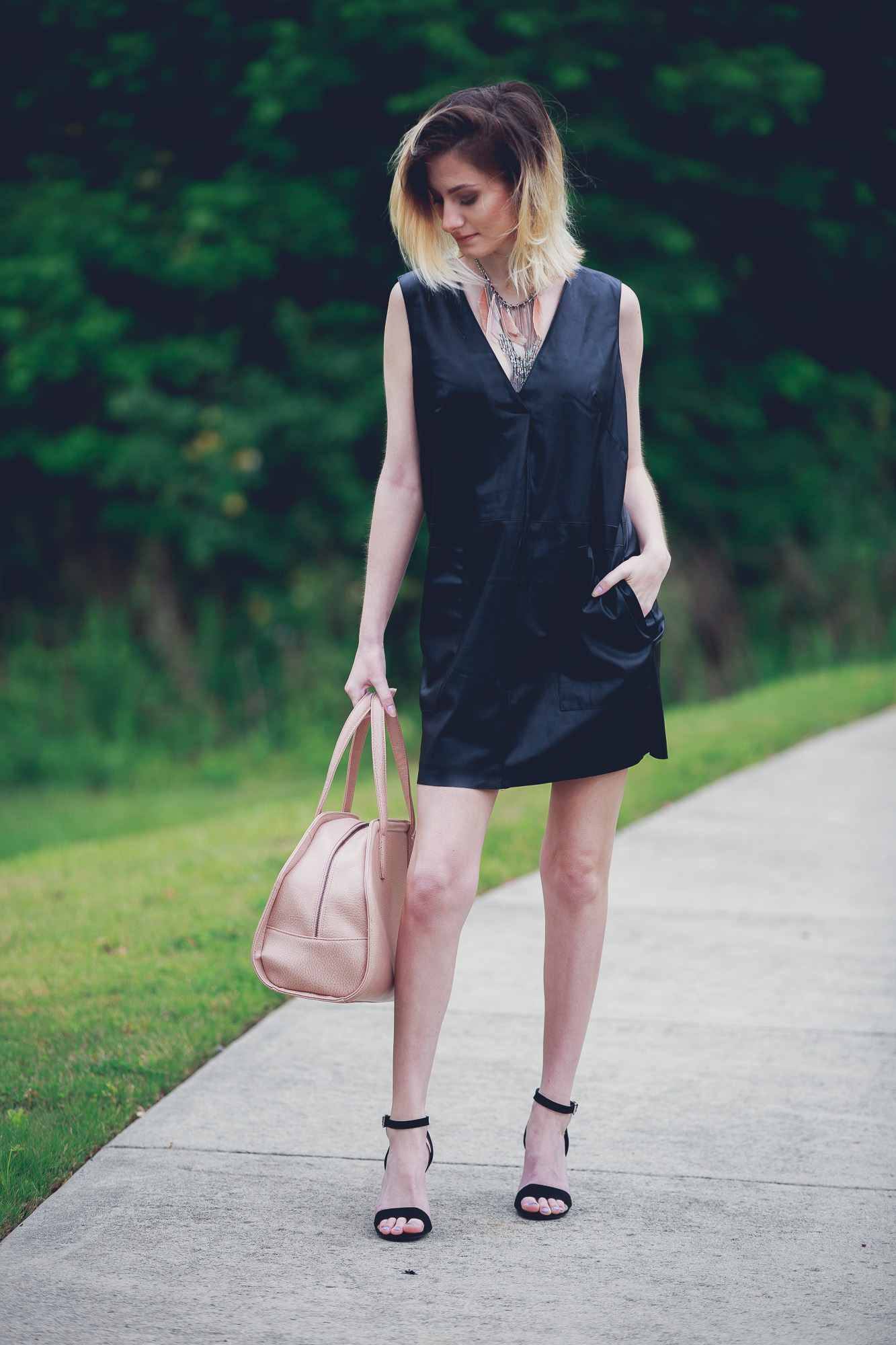 Lifestyle and Fashion Blogger, Jessica Linn, wearing a faux leather Forever21 dress, ASOS heels, a statement necklace from Target, earrings from the Baublebar, and carrying a Matt and Nat purse.