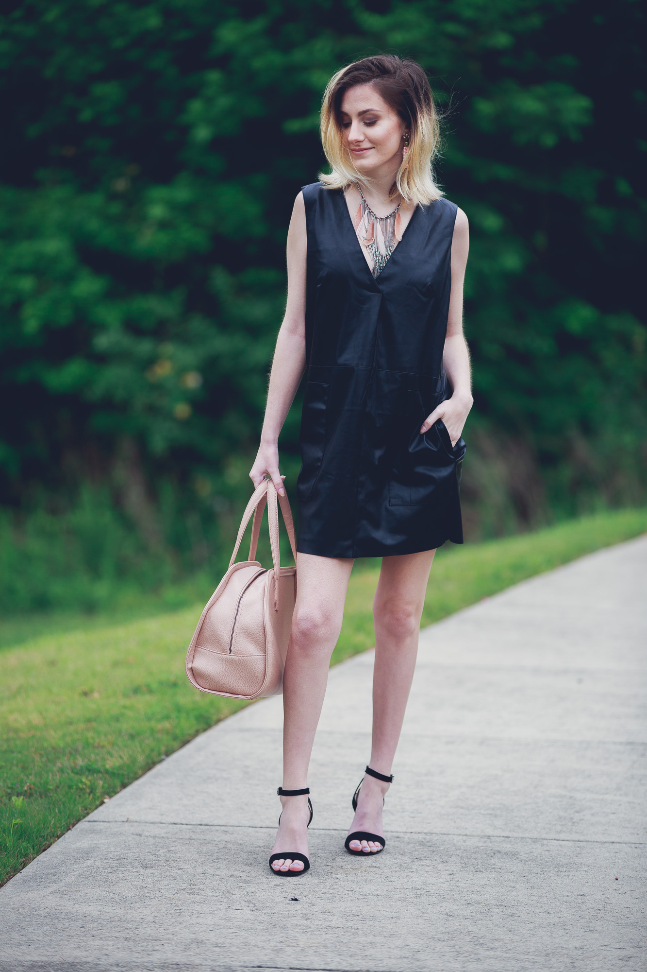 Lifestyle and Fashion Blogger, Jessica Linn, wearing a faux leather Forever21 dress, ASOS heels, a statement necklace from Target, earrings from the Baublebar, and carrying a Matt and Nat purse.