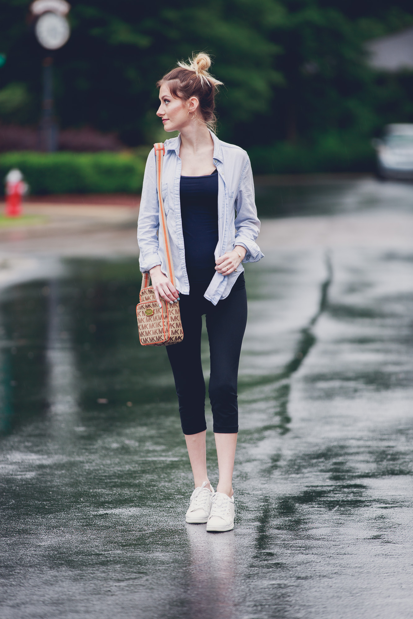 Fashion and lifestyle blogger Jessica Linn from Linn Style wearing a casual outfit: Target maternity leggings, an aeropostale tank top, and chambray button up, Target tennis shoes, Charming Charlie's earrings, and a Michael Kors purse in Cary North Carolina