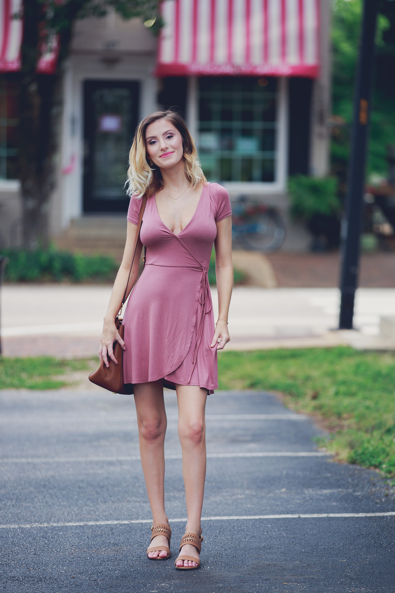 Lifestyle and Fashion blog Linn Style bye Jessica Linn Outfit of the Day post and summer outfit inspiration wearing a mauve Forever21 wrap dress (great for pregnancy) a Dogearred jewelry lotus necklace, a Kendra Scott bracelet, World Market earrings, brown low sandal heels from Ross, and carrying a Michael Kors tan purse while walking in Historic Downtown Cary North Carolina.