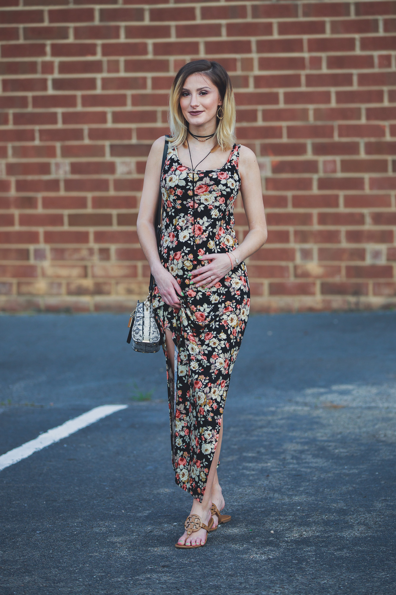 Lifestyle, fashion, and beauty blogger / vlogger Jessica Linn wearing a floral black maxi dress, Tory Burch sandals, a Coach purse, and earrings from CY Design Studio in Cary North Carolina on Linn Style