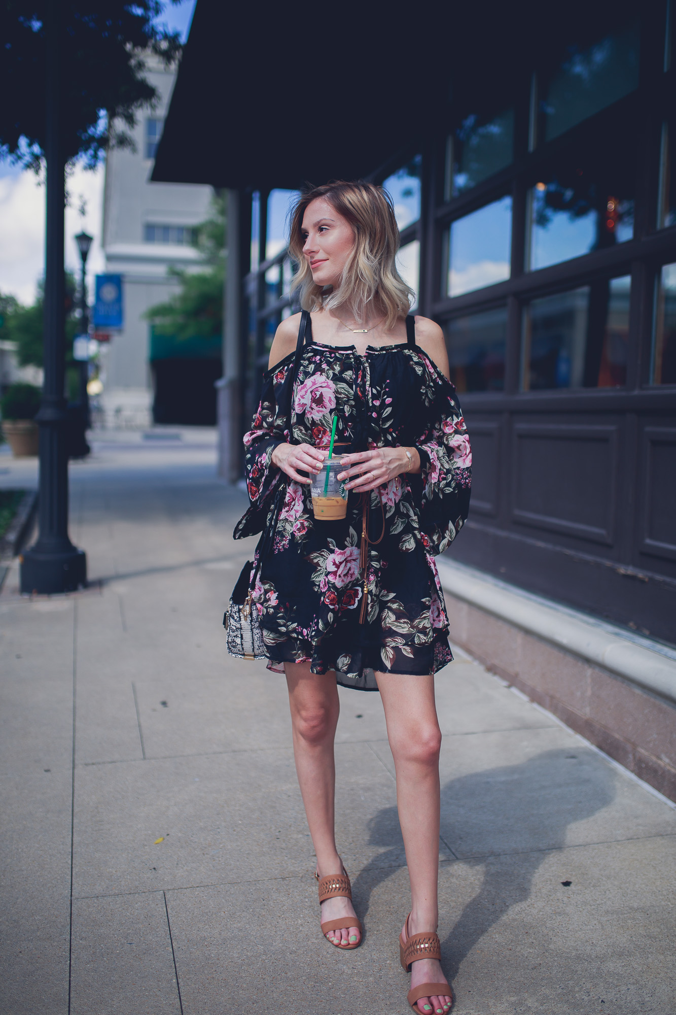 Fashion, lifestyle, and beauty blogger / vlogger Jessica Linn from Linn Style wearing an off the shoulder black floral mid thigh dress with Matisse footwear heels, a coach purse, and a Mamma Bear necklace from CY Design Studio 