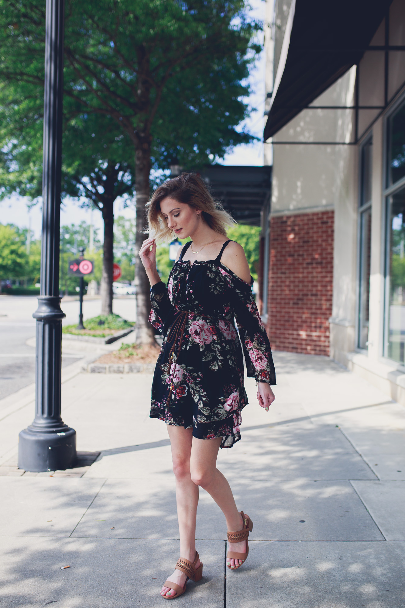 Fashion, lifestyle, and beauty blogger / vlogger Jessica Linn from Linn Style wearing an off the shoulder black floral mid thigh dress with Matisse footwear heels, a coach purse, and a Mamma Bear necklace from CY Design Studio in North Hills Raleigh North Carolina