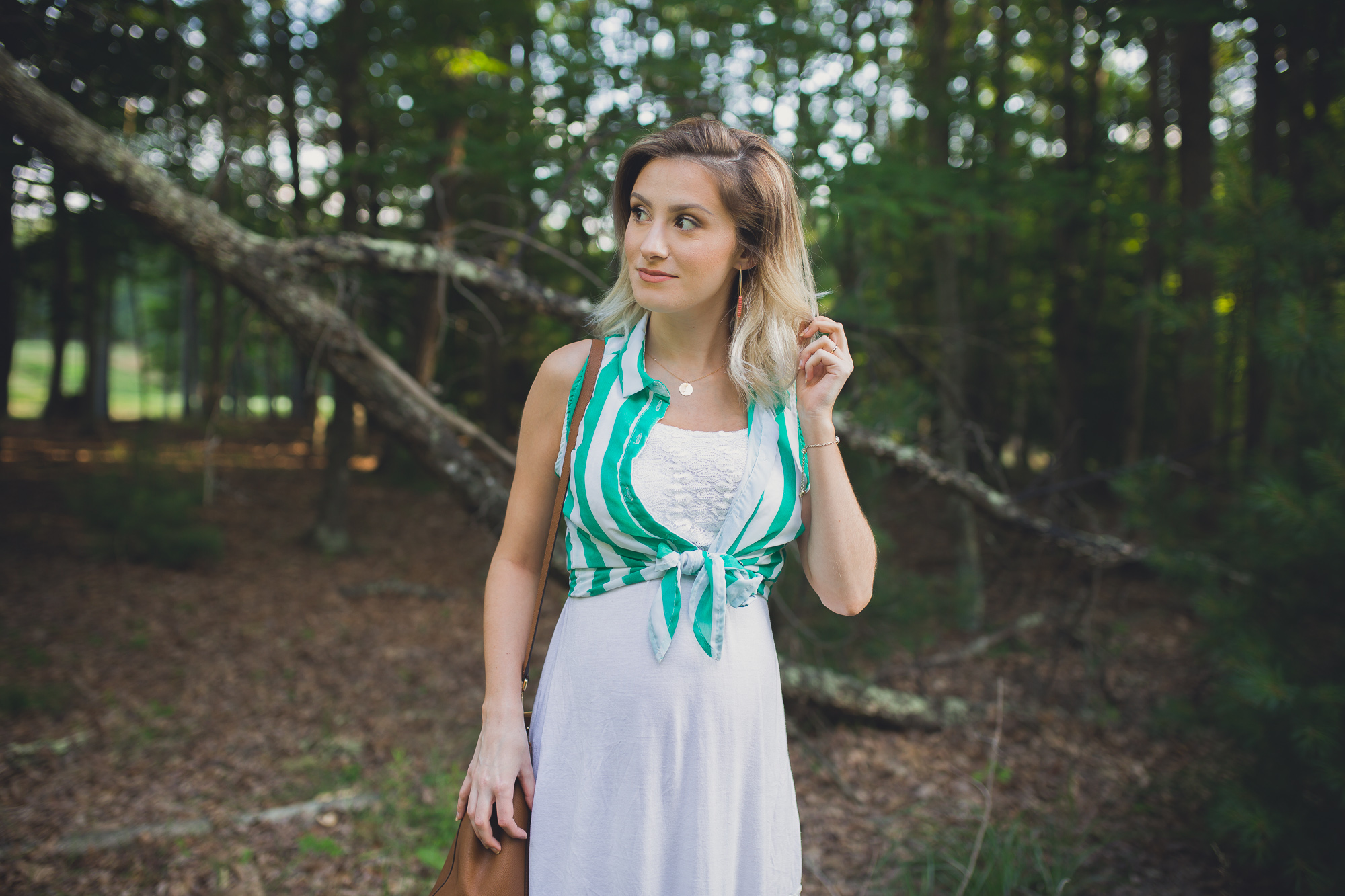 Fashion, lifestyle, and beauty blogger/ vlogger wearing maternity fashion a white sundress with green stripe accents and jewelry from CY Design Studio and Tory Burch Sandals.