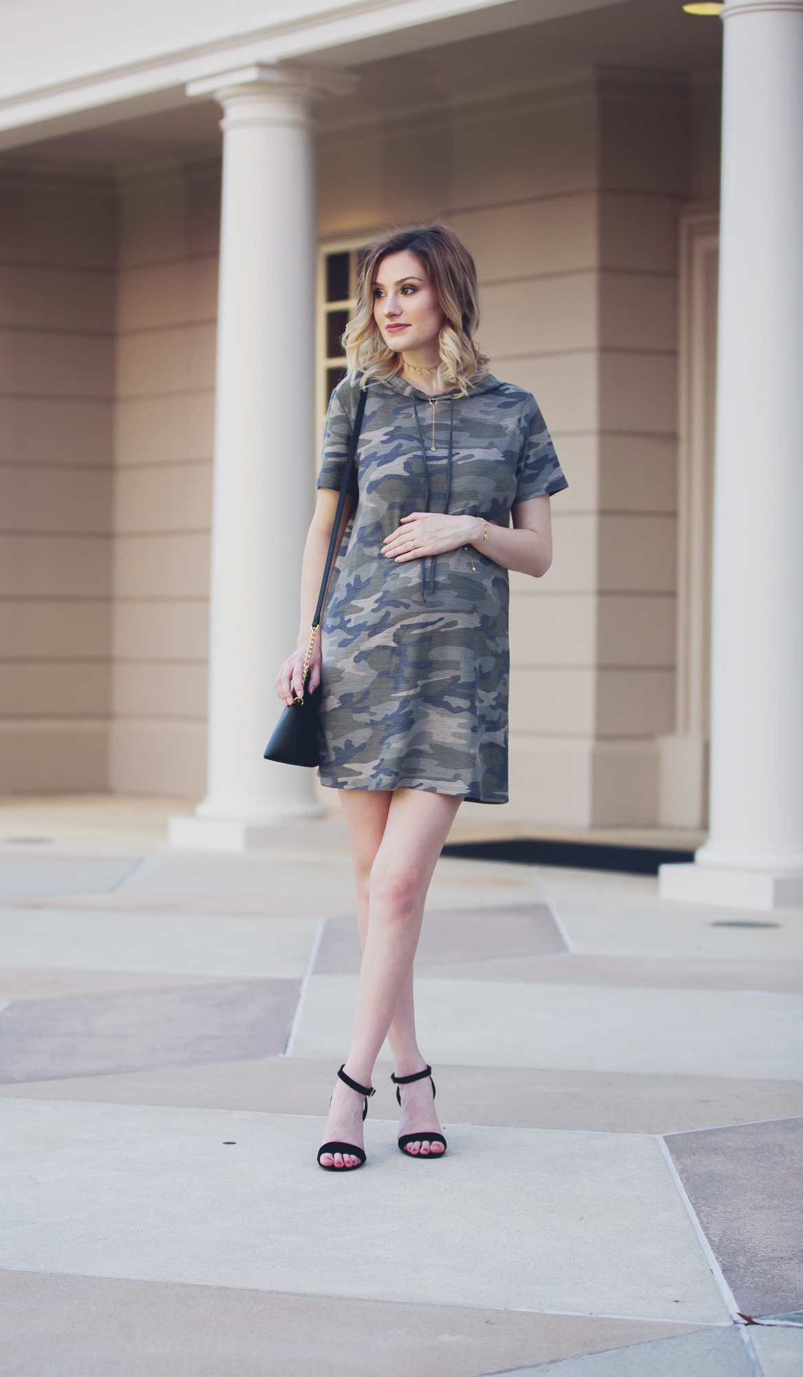 Lifestyle Fashion and beauty blogger Jessica Linn from Linn Style wearing a Forever21 sweater dress and Michael Kors purse in downtown Raleigh North Carolina. Non-maternity maternity outfits. Camo sweater dress