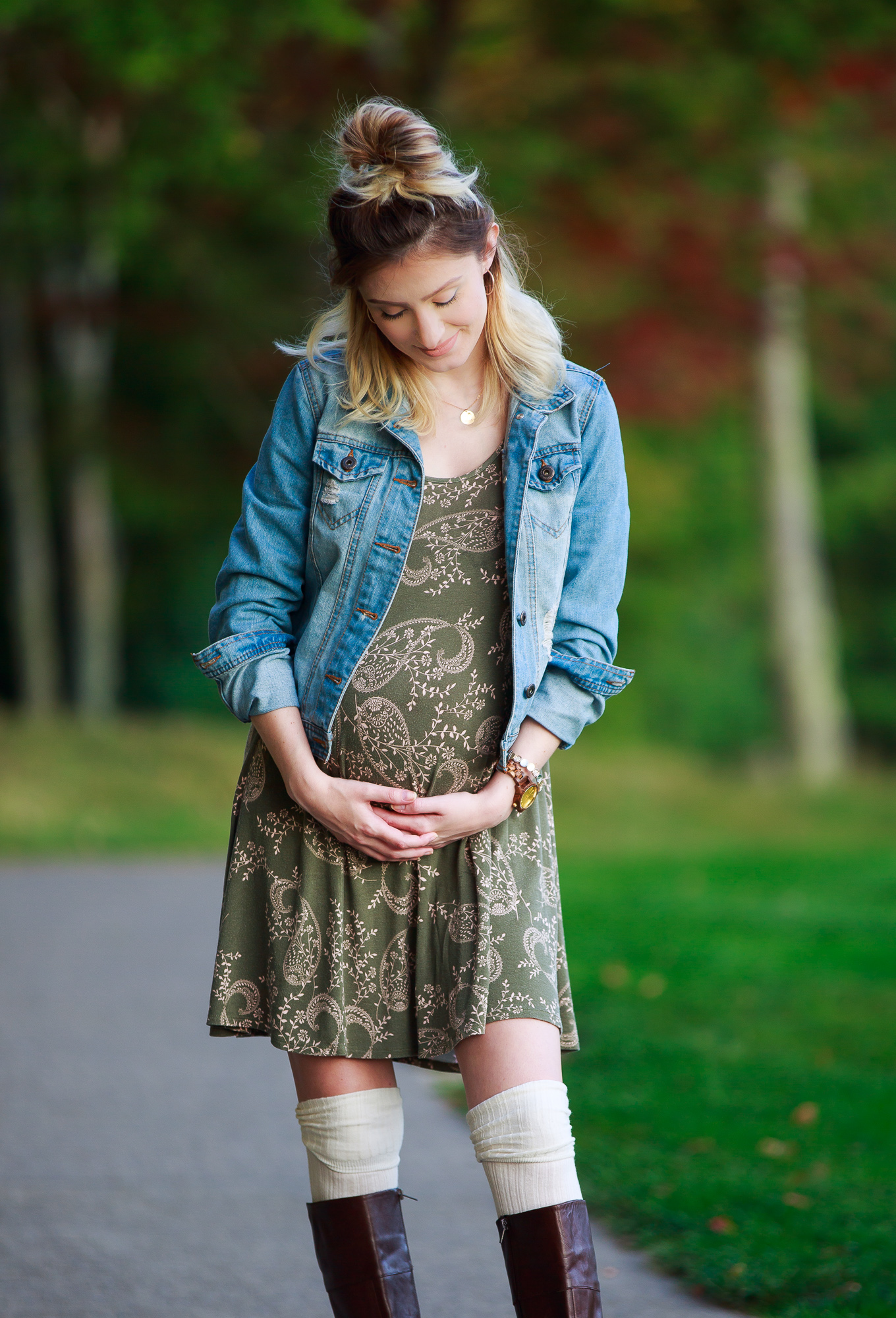 Lifestyle and fashion blogger Jessica Linn wearing a Charlotte Russe olive colored dress with a neutral paisley pattern, a denim jacket, thigh high socks, and Ralph Lauren boots. Perfect fall maternity outfit!