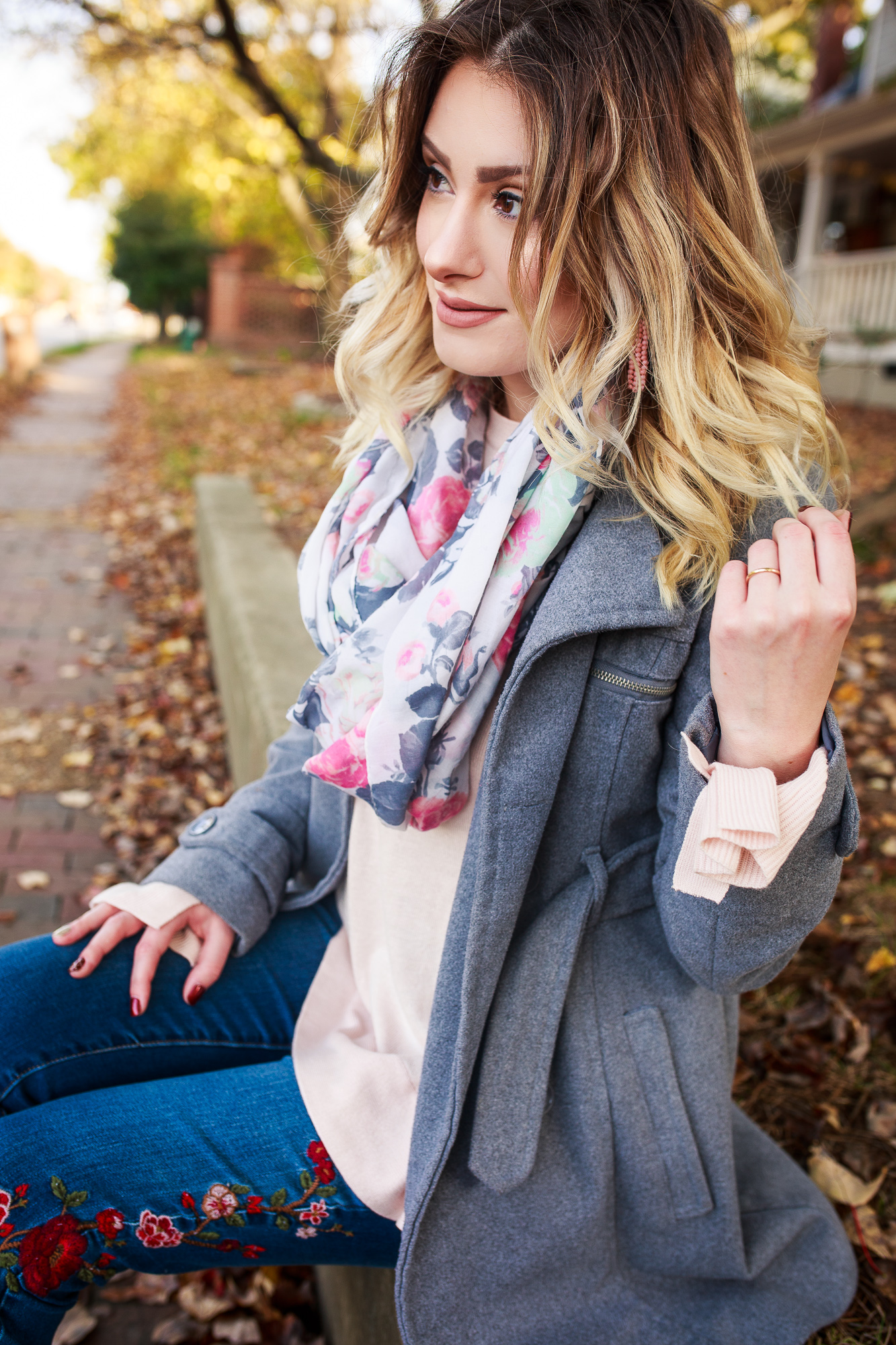 A New Day Clothing Brand From Target. Fashion and lifestyle blogger Jessica Linn from Linn Style wearing a pink ruffle bell sleeve sweater, floral embroidered skinny jeans, a gray peacoat, blue velvet booties, and a floral Scarf from World Market. Carrying a pearl gray Michael Kors purse