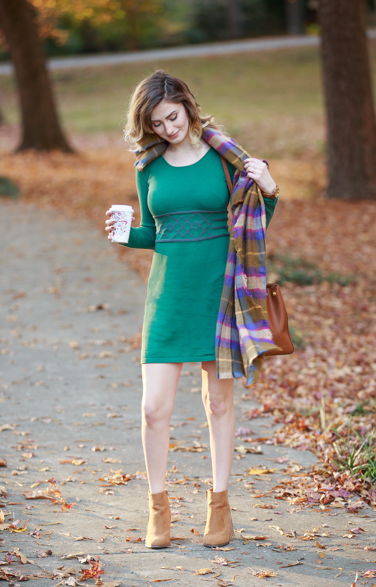 North Carolina fashion and lifestyle blogger Jessica Linn wearing a sweater dress from Aventura. Aventura clothes are made from organic sustainable materials promoting sustainable fashion. Also wearing fringe booties from Forever21, a green plaid scarf from Target, and a Michael Kors purse and a JORD wood watch.