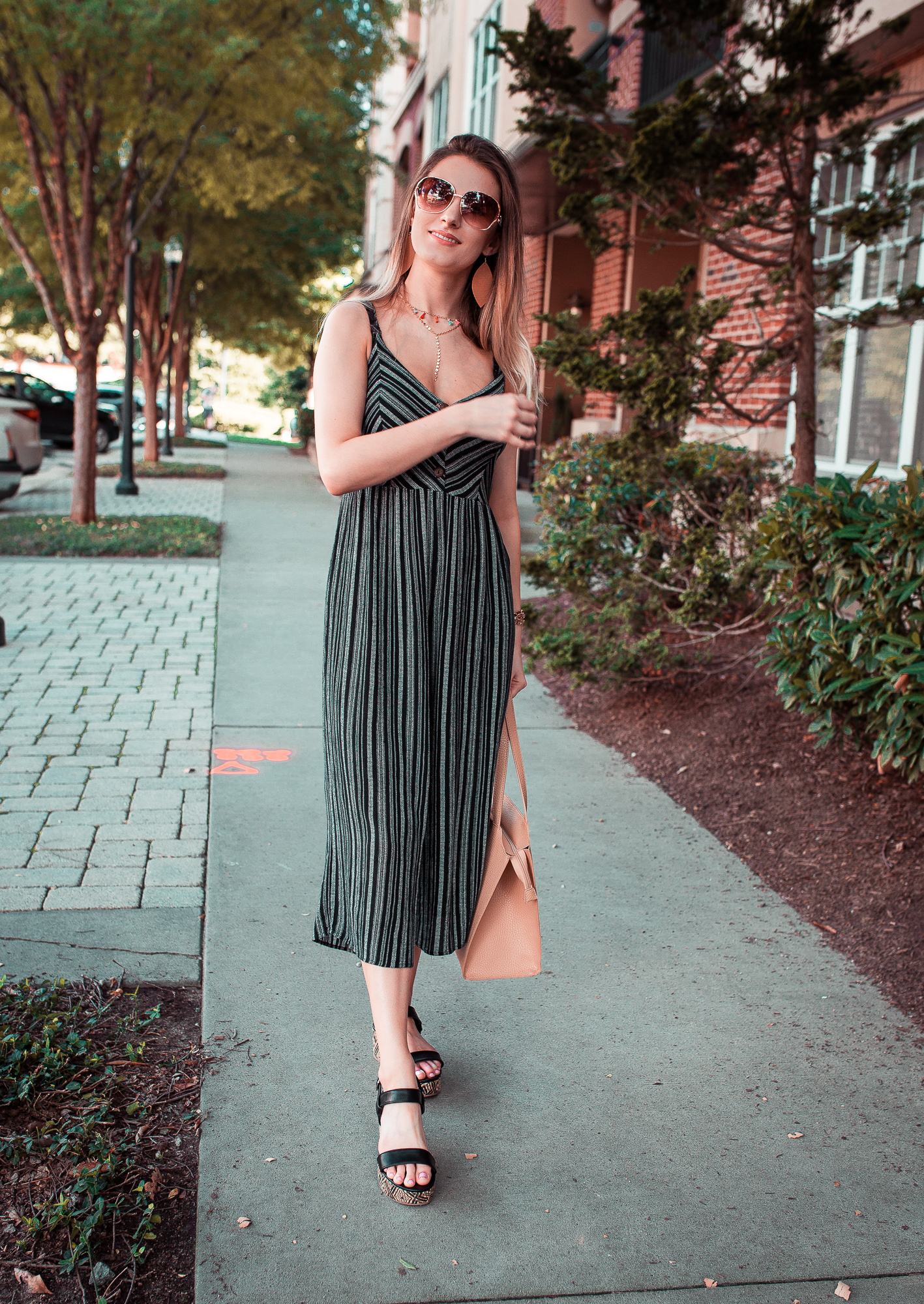 North Carolina fashion and lifestyle blogger Jessica Linn styling a navy striped jumpsuit from Forever21, platform sandals from Target, a layered tassel chocker from bauble bar, and vegan leather earrings from RSA Studios.