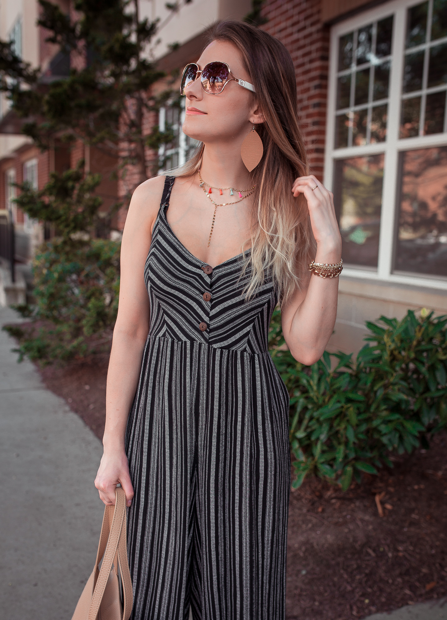 North Carolina fashion and lifestyle blogger Jessica Linn styling a navy striped jumpsuit from Forever21, platform sandals from Target, a layered tassel chocker from bauble bar, and vegan leather earrings from RSA Studios.